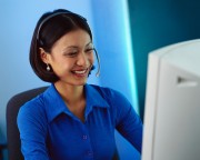 Businesswoman Wearing Headset at Computer